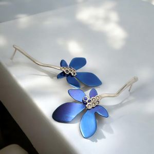 Χειροποίητα σκουλαρίκια με μπλε τιτάνιο και ασημένια λεπτομέρεια, σε σχέδιο λουλουδιού από το Dono Di Dio Jewels.