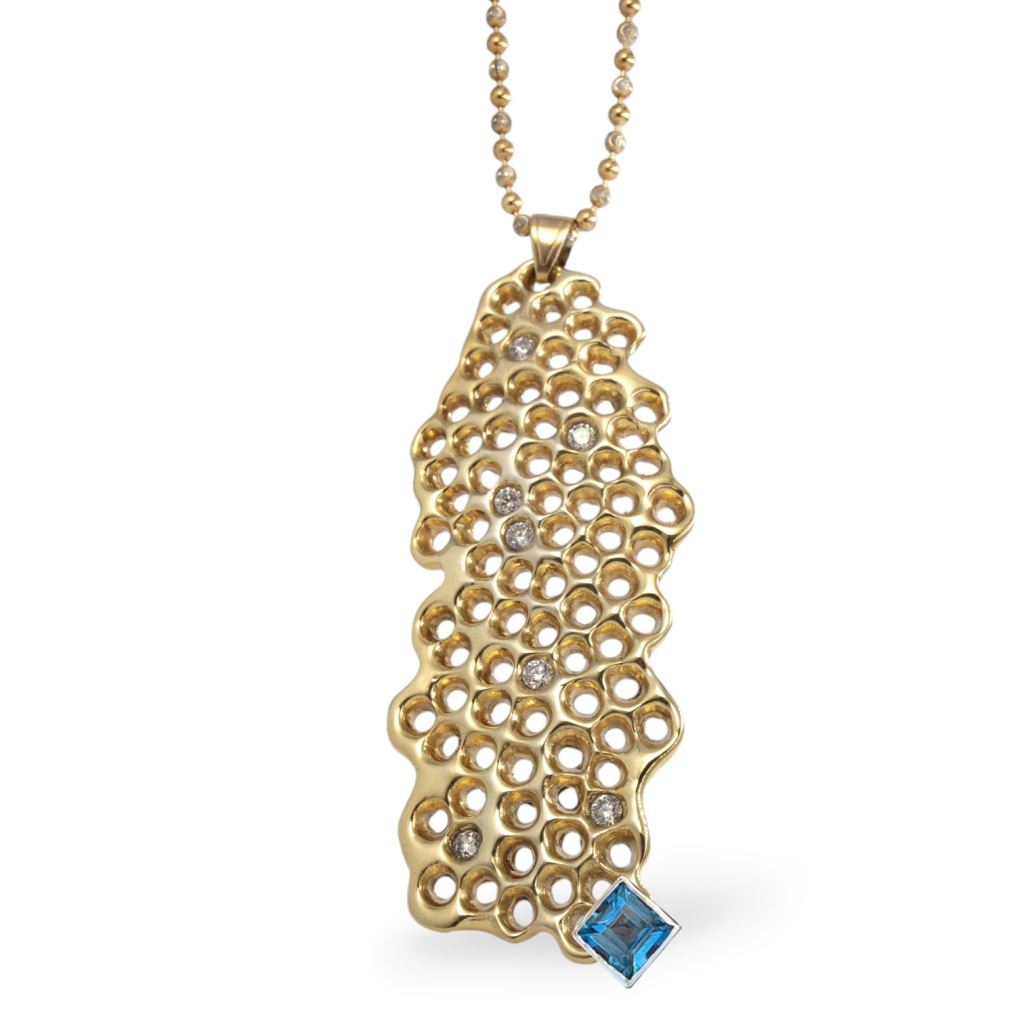 Handcrafted gold honeycomb necklace with a blue topaz gemstone and diamond accents, hanging on a silver chain.