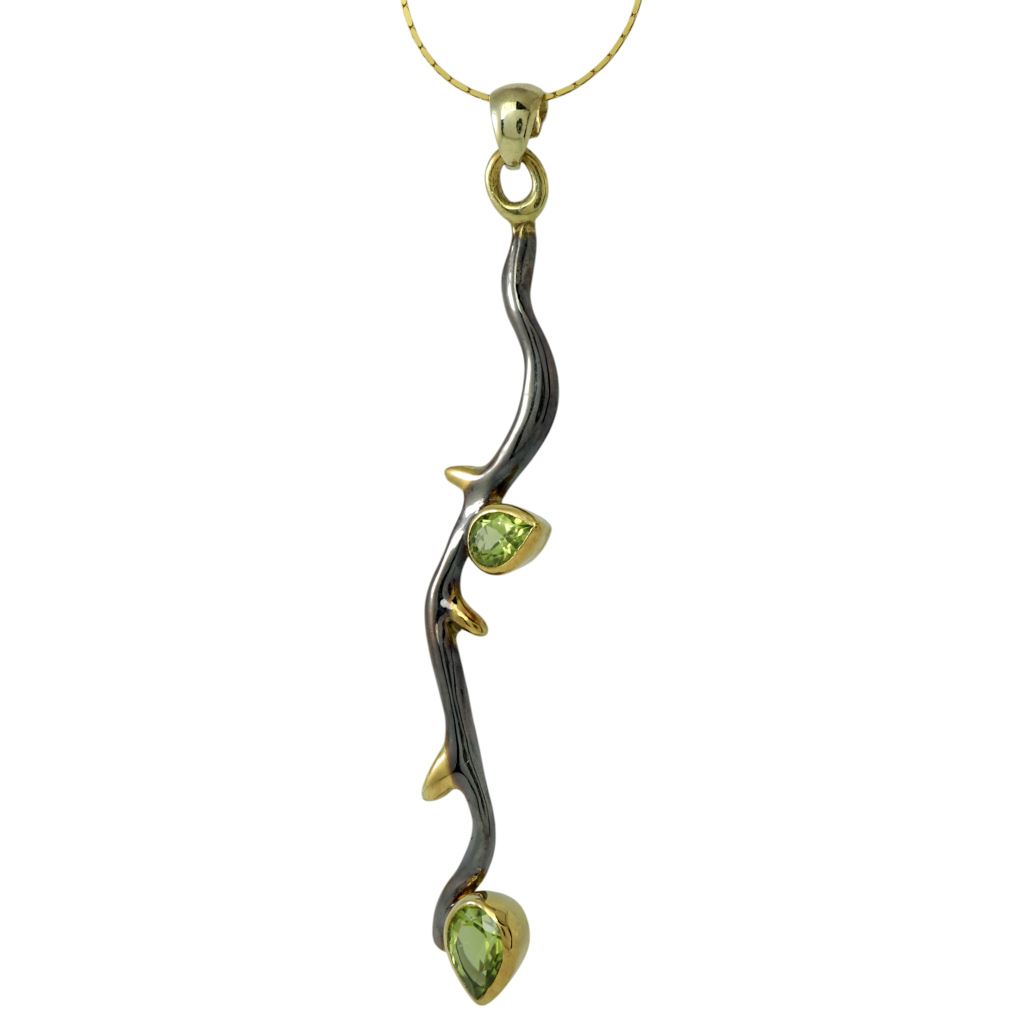 Silver necklace with a nature-inspired branch design, adorned with peridot gemstones and gold-plated details. Elegant and artistic jewelry for women.